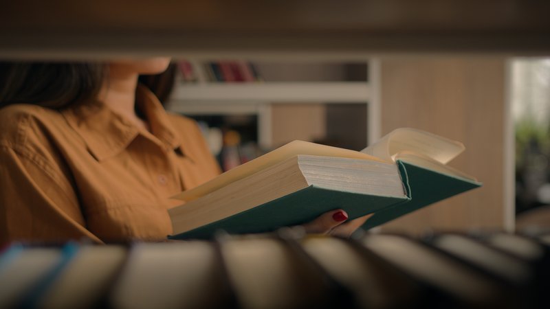 Femme lisant un livre en bibliothèque pour cultiver sa dimension mentale et son esprit